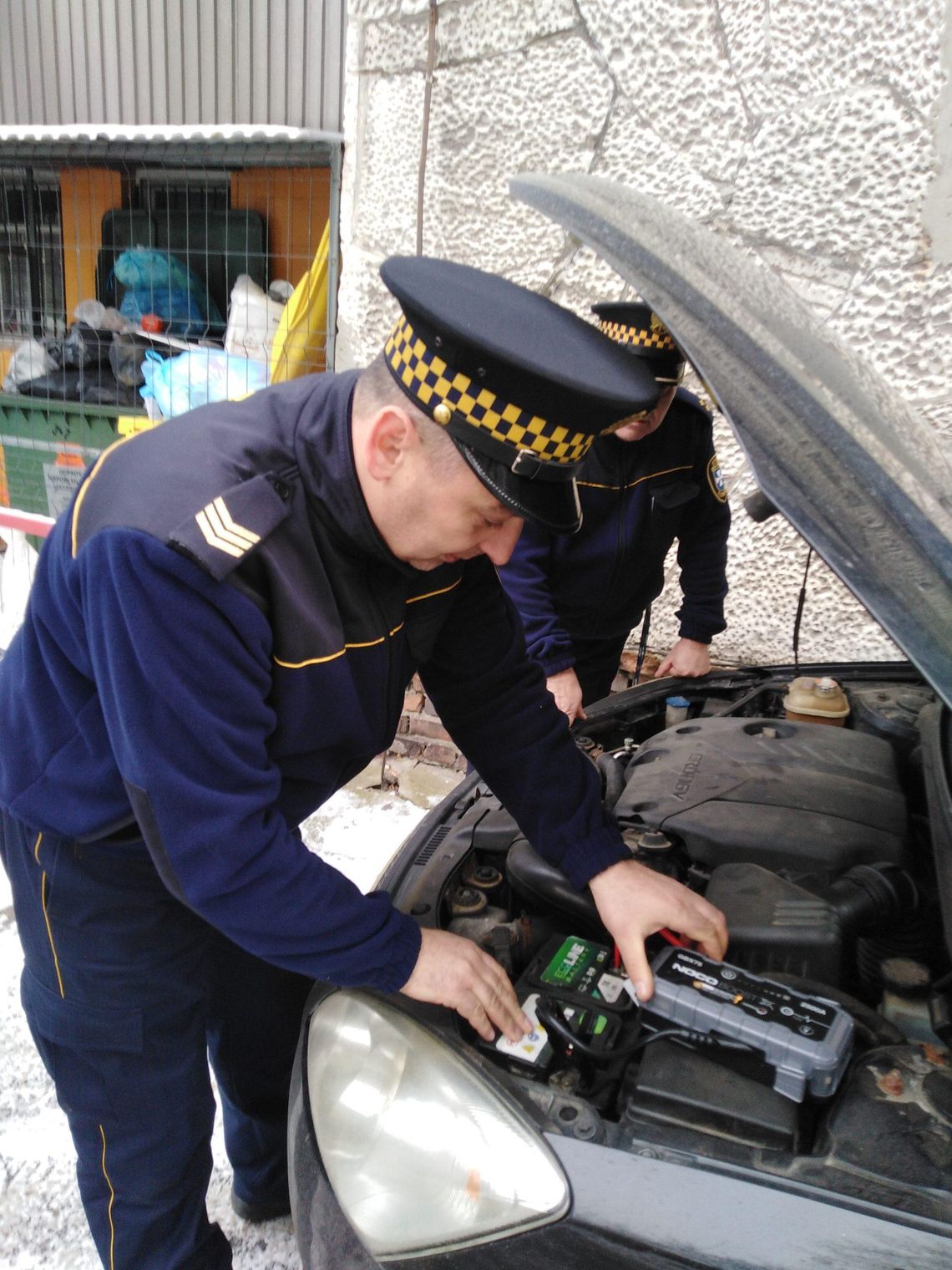 Strażnicy miejscy pomagają mieszkańcom odpalać samochody