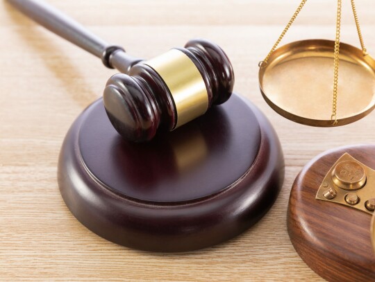 High angle shot of a gavel and a scale on a wooden surface