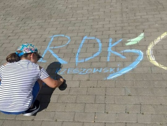 dziewczynka malująca kreda napis RDK